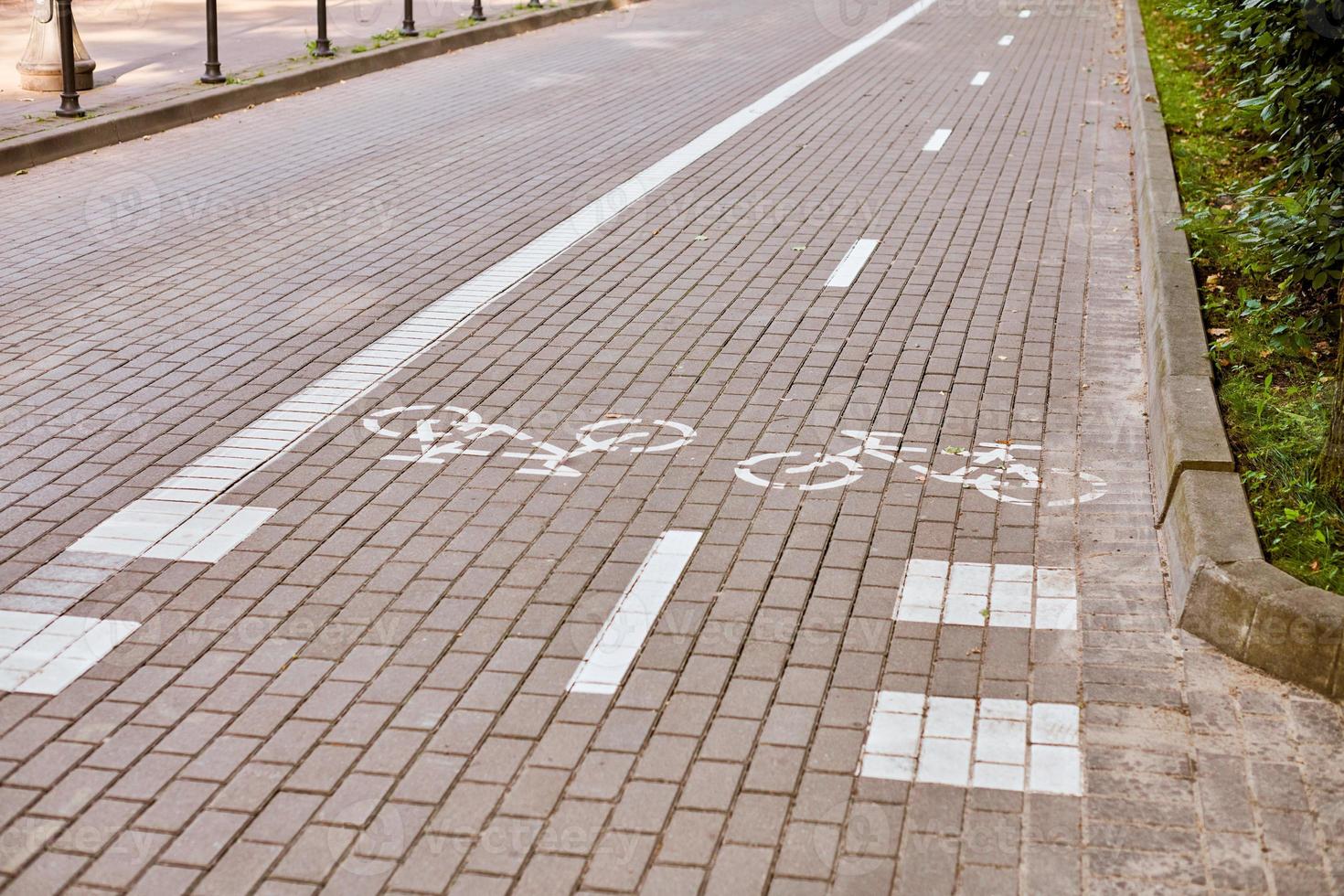 tvåvägs cykelväg, markering av cykelväg på trottoaren, vitmålad cykelskylt på väg, cykelsymbol foto