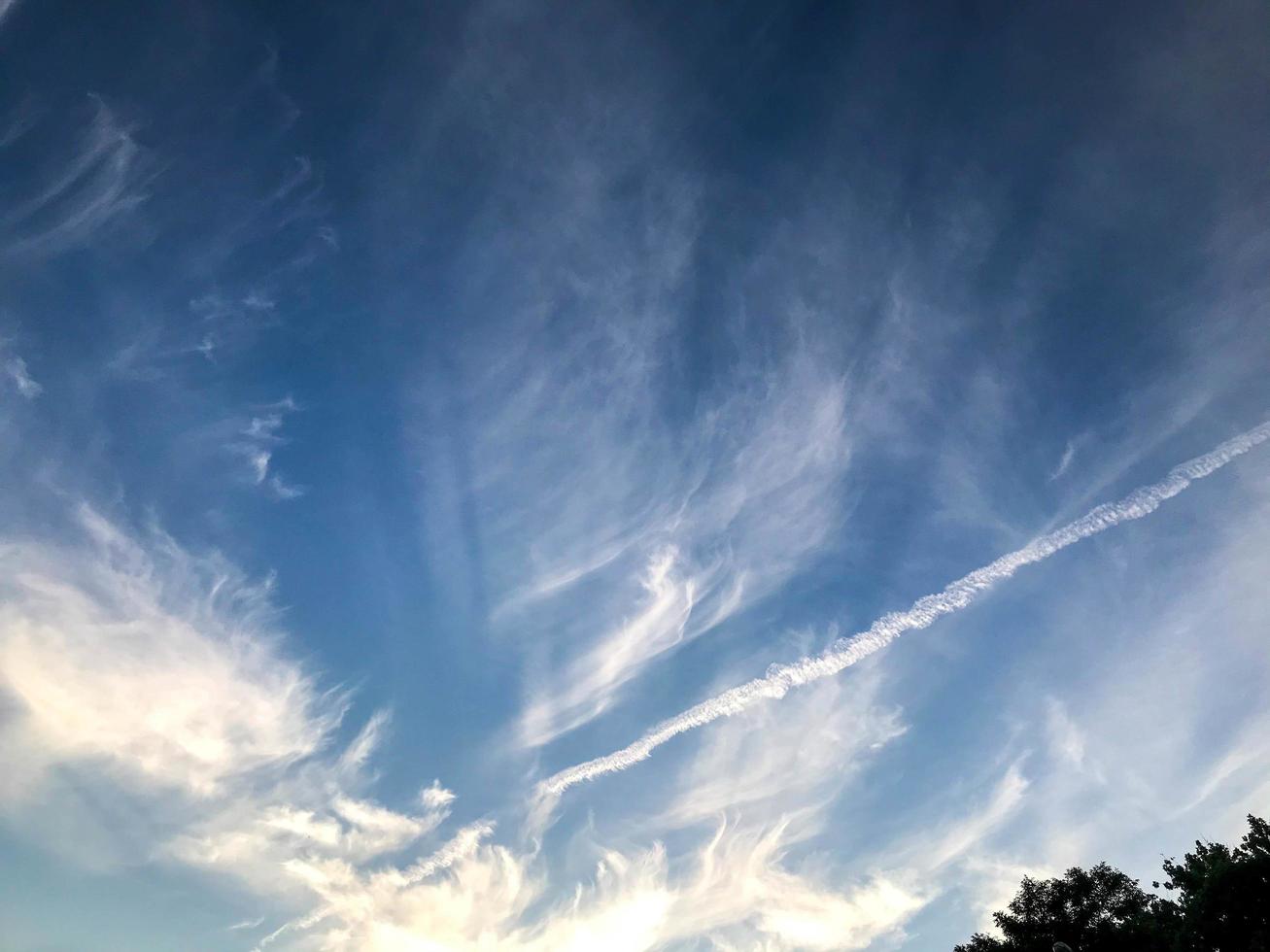 blå himmel med vit moln. naturlig fenomen, skön moln. i de distans, spår av vit från en flygande plan är synlig. vattenfärg moln, ozon lager. sommar himmel foto