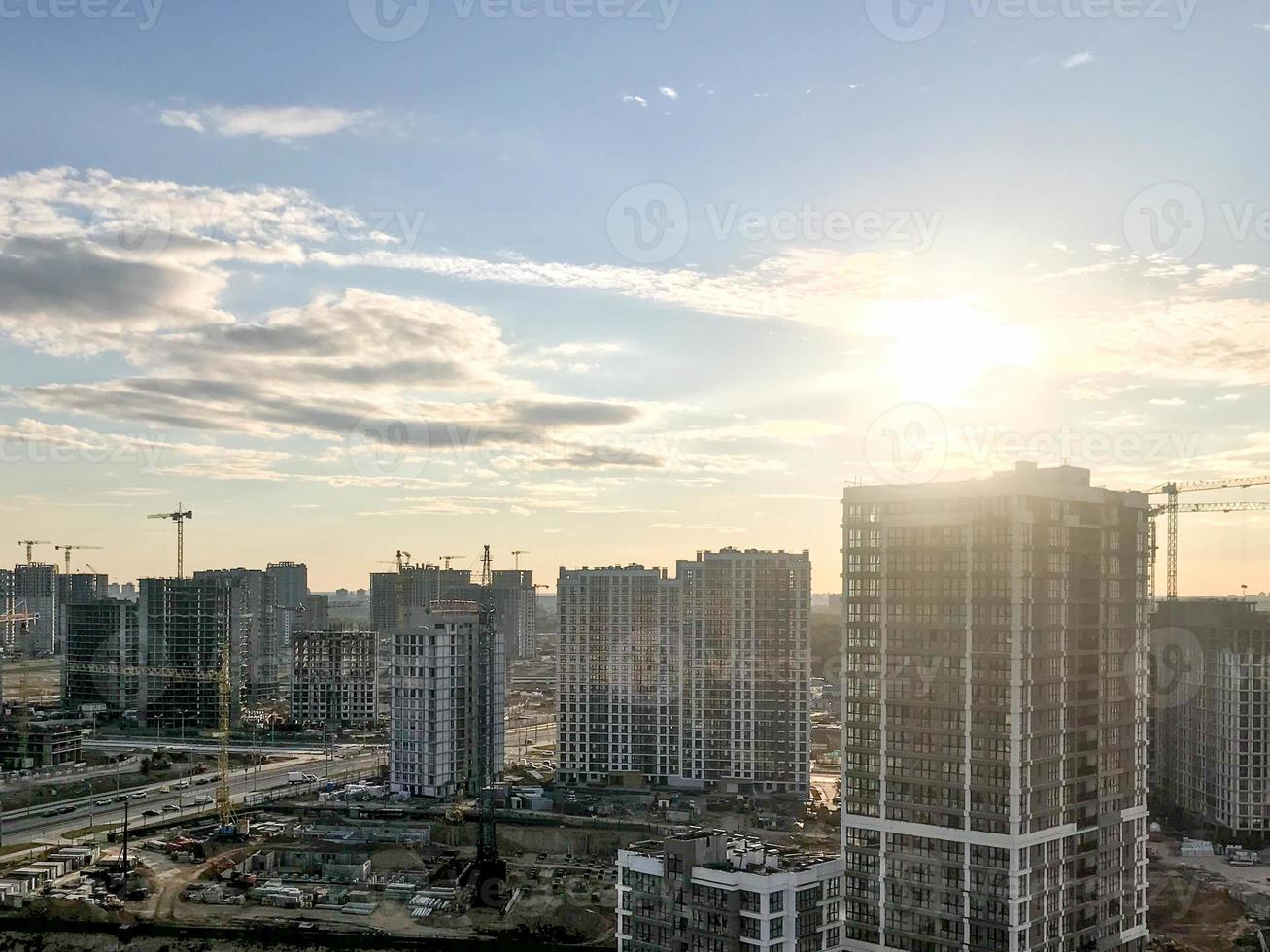 en ny grannskap i de stad. skytte från en höjd. urban urban landskap. lång glas flera våningar byggnader av annorlunda färger och annorlunda höjder. nära konstruktion kranar, foto