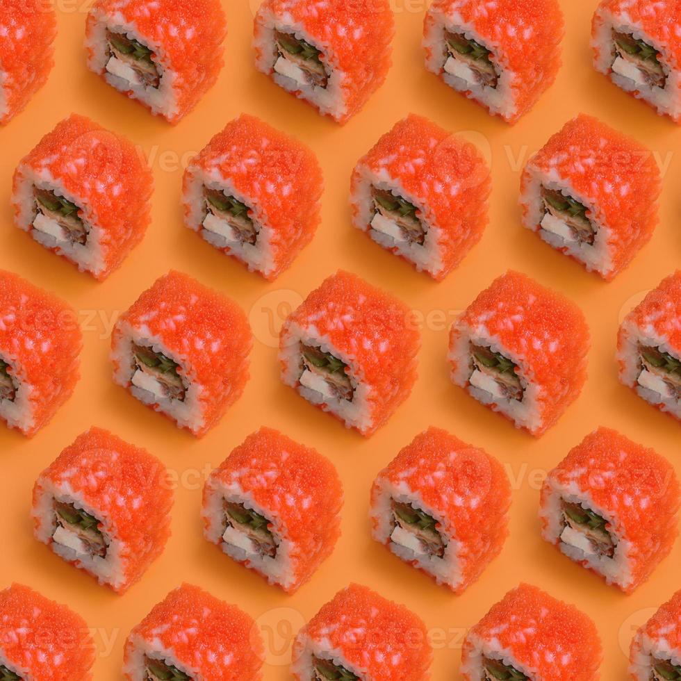 kalifornien maki sushi rullar med kaviar och masago på orange bakgrund. minimalism topp se platt lägga mönster med japansk mat foto