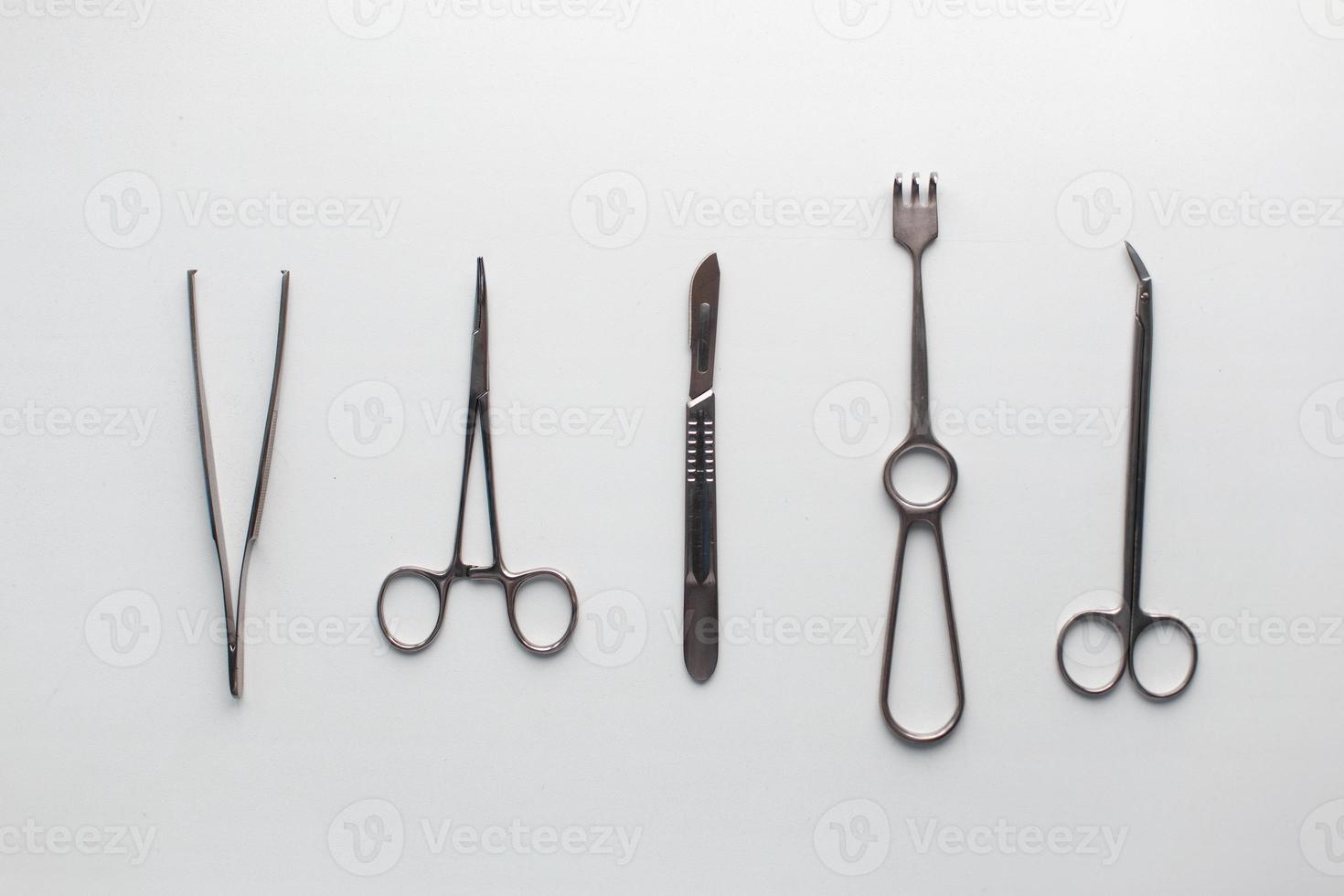 kirurgisk instrument pincett, tång, klämma de blad, skalpell, sax på en vit tabell. foto