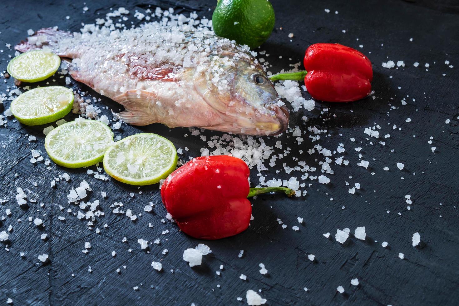 färsk tilapia fisk med salt och kryddor foto