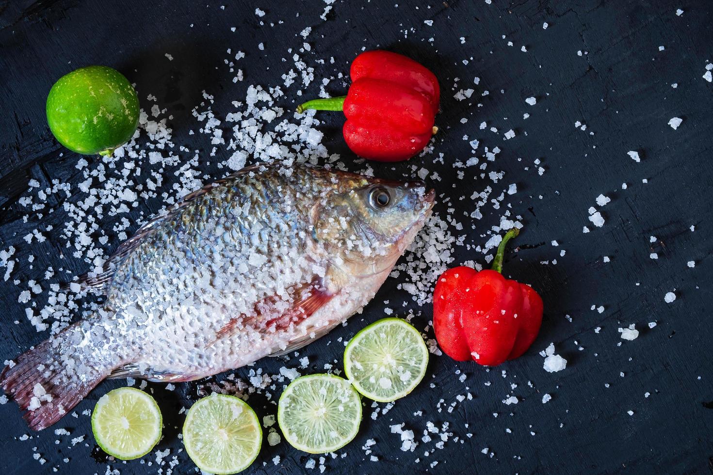 färsk tilapia fisk med salt och kryddor foto