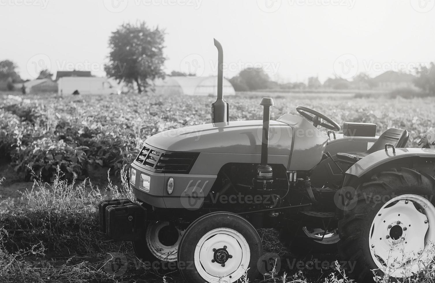 ett tömma traktor står på en bondens fält. svart och vit. bruka maskineri och Utrustning. jordbruk industri foto