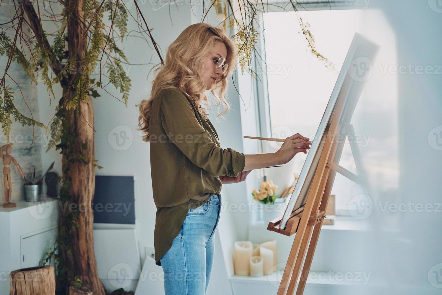 sida se av attraktiv ung kvinna målning i konst studio foto
