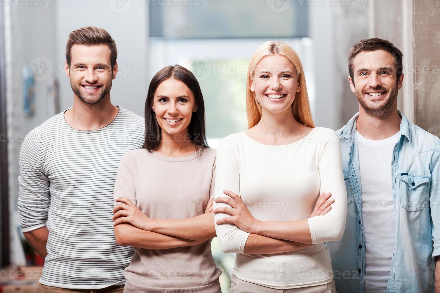 ung och framgångsrik team. fyra ung företag människor i smart tillfällig ha på sig stående stänga till varje Övrig och leende diskuterar foto