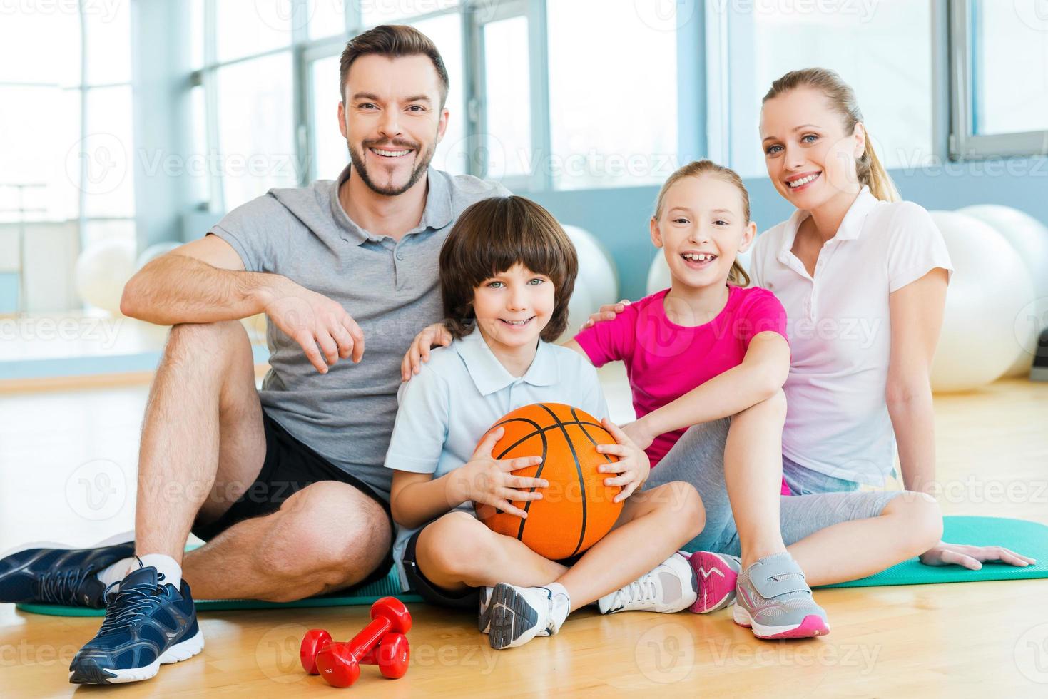 Lycklig till vara en familj. Lycklig sportig familj bindning till varje Övrig medan Sammanträde på övning matta tillsammans foto