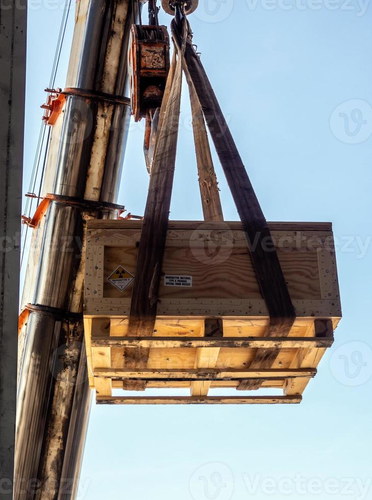 kranen lyfter den radioaktiva instrumenthållaren transport trälåda foto