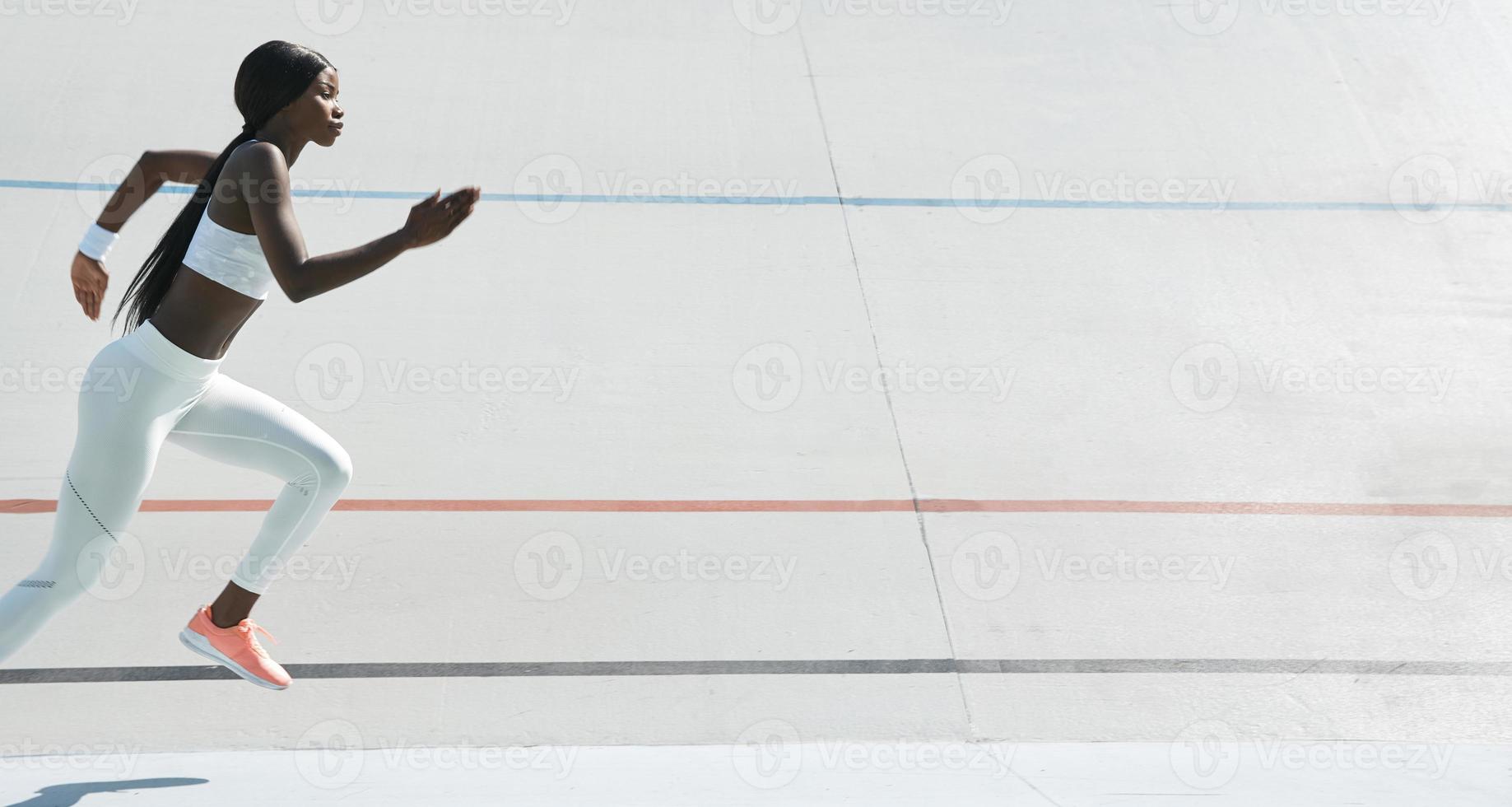 skön ung afrikansk kvinna i sporter Kläder löpning på Spår utomhus foto