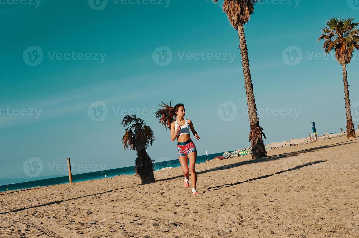 fast besluten till vinna. full längd av skön ung kvinna i sporter Kläder joggning medan utövar utomhus foto