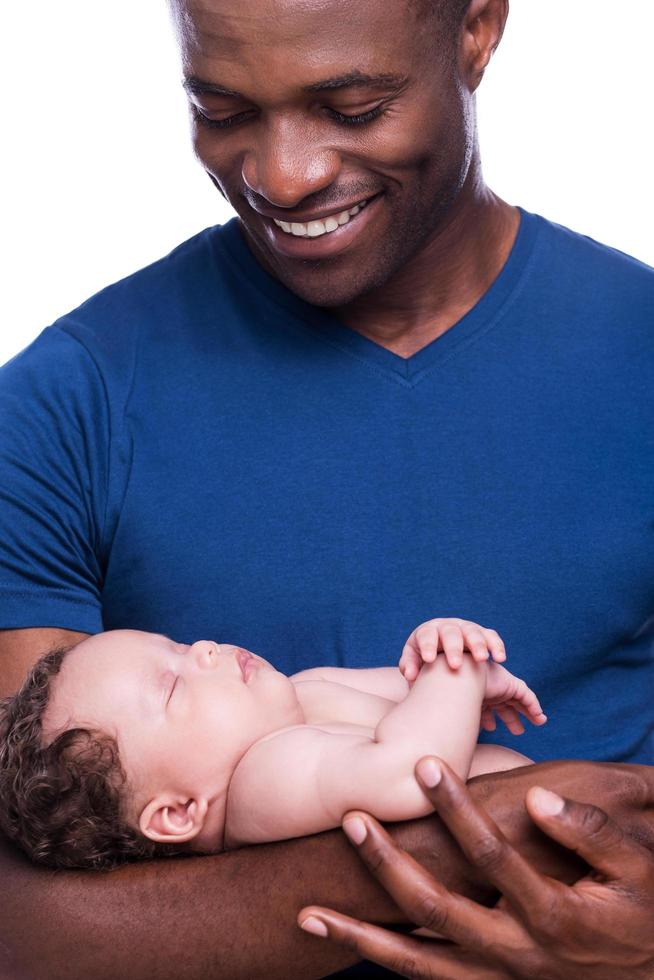 stolt till vara en pappa. närbild av Lycklig ung afrikansk man innehav hans liten bebis och leende medan stående isolerat på vit foto
