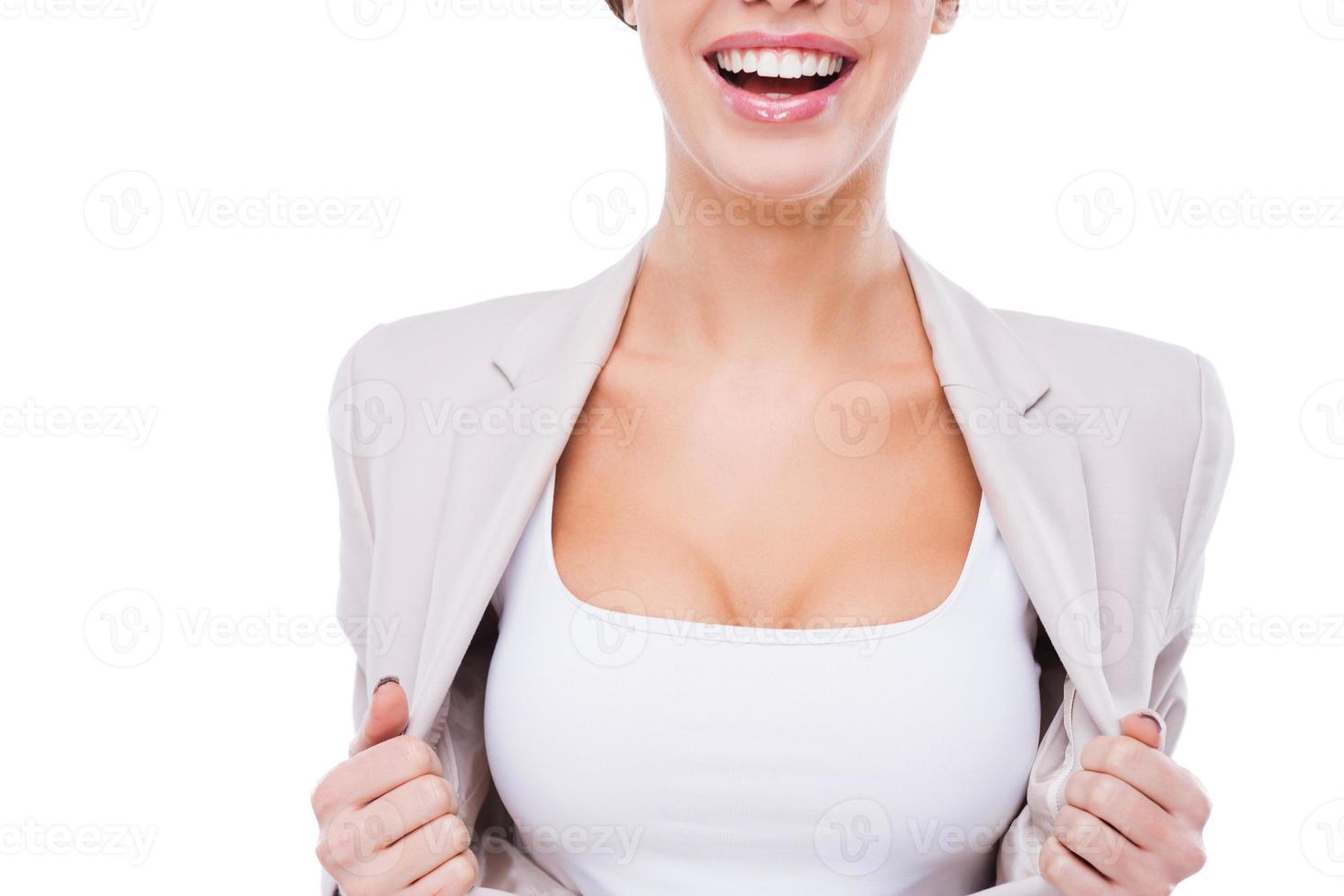 villig till vara de först i företag. närbild av Lycklig ung affärskvinna tar av henne jacka och som visar henne perfekt klyvning medan stående mot vit bakgrund foto