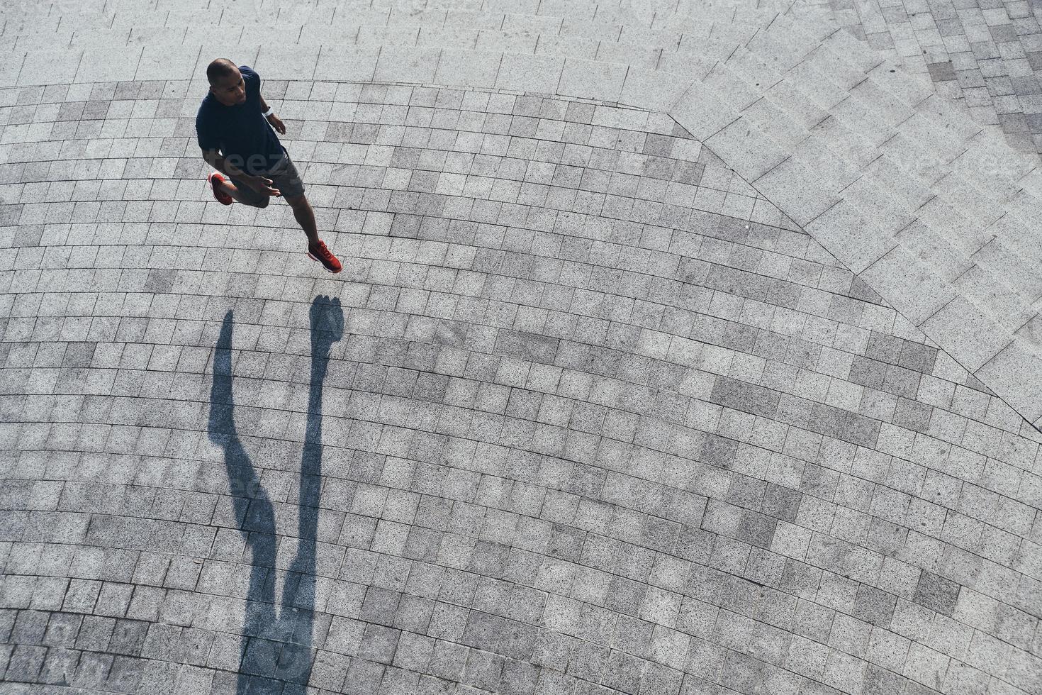 starkare och snabbare. topp se av ung afrikansk man i sporter Kläder joggning medan utövar utomhus foto