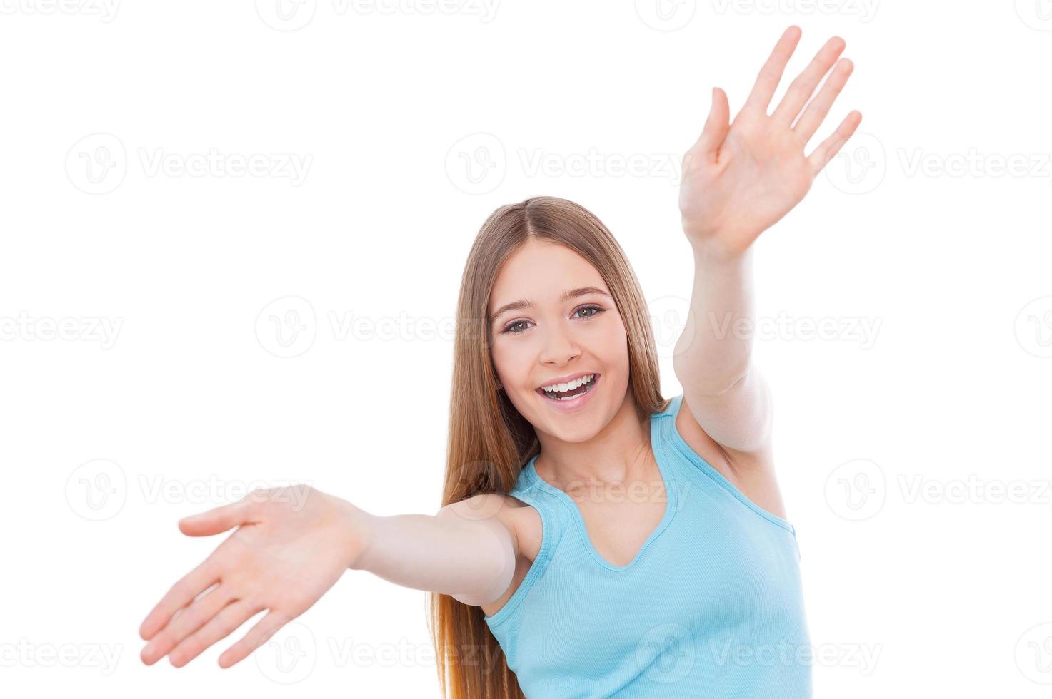 fokus på mig glad Tonårs flicka kvinna stretching ut händer och leende medan stående isolerat på vit foto