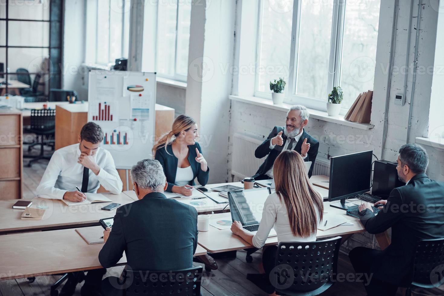 topp se av medarbetare diskuterar Nästa företag steg medan arbetssätt tillsammans med kollegor i de modern kontor foto