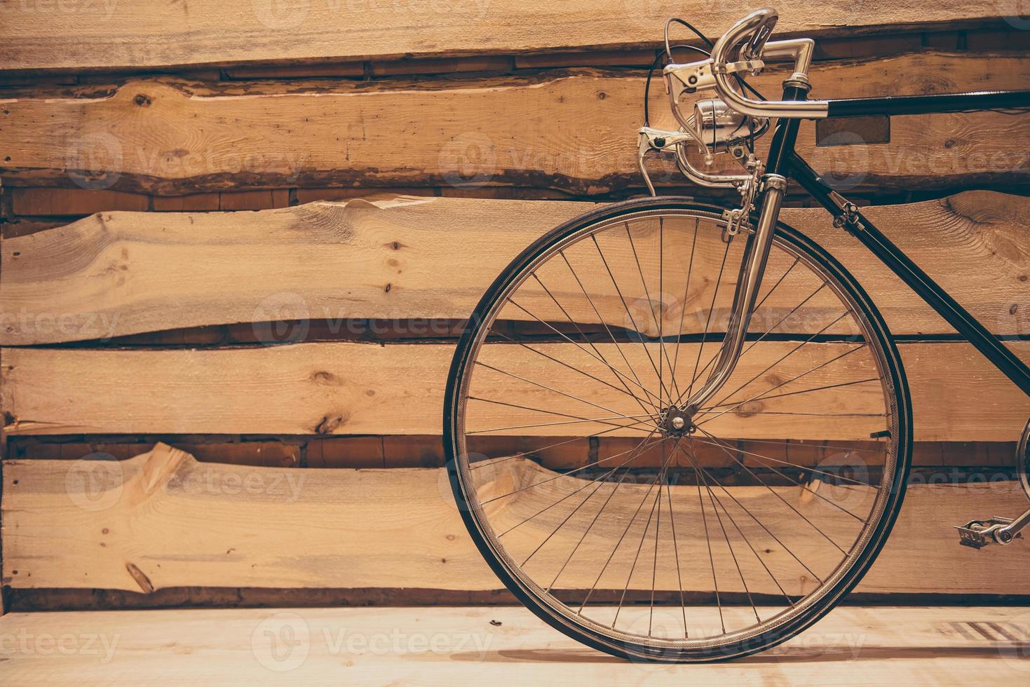 gammaldags elegans. närbild av retro styled cykel stående mot grov trä- vägg foto