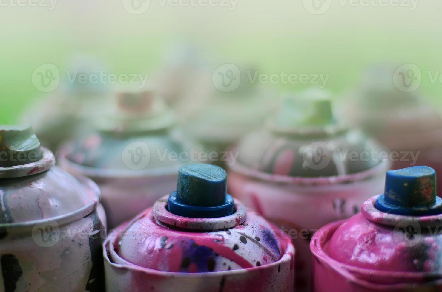 en massa av Begagnade spray burkar av måla närbild. smutsig och insmord burkar för teckning graffiti. de begrepp av en sotning och slarvig teckning av måla. kreativ konst bild foto