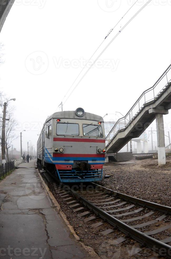 de järnväg Spår i en dimmig morgon. de ukrainska förorts tåg är på de passagerare station. fisköga Foto med ökade förvrängning