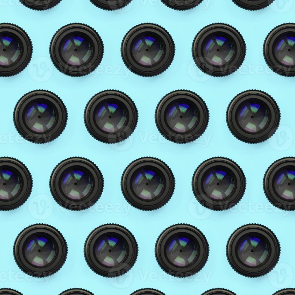 en få kamera linser med en stängd öppning lögn på textur bakgrund av mode pastell blå Färg papper foto