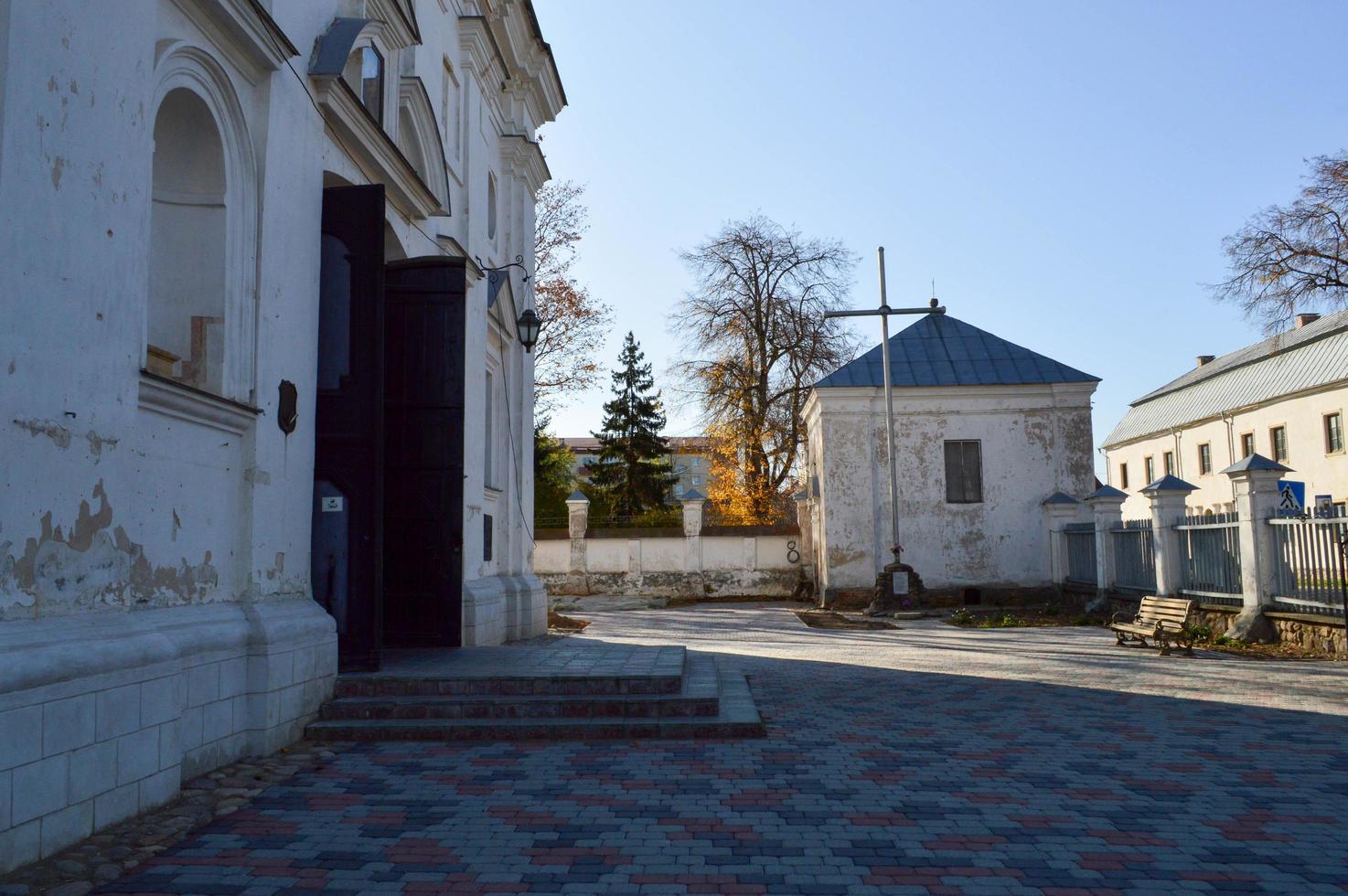 gammal gammal vit fattig sten sjaskig kristen ortodox kyrka med går över foto