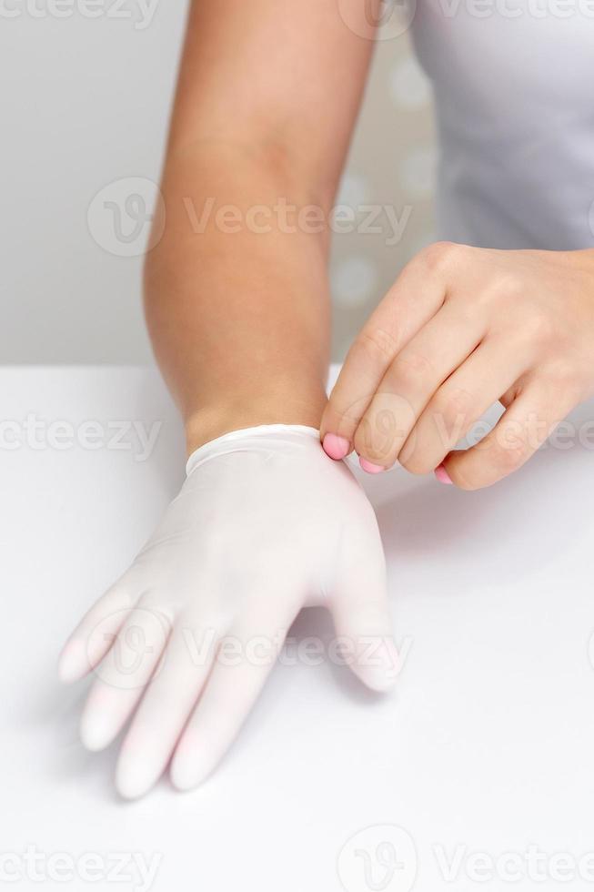 kvinna händer sätta på skyddande handskar foto