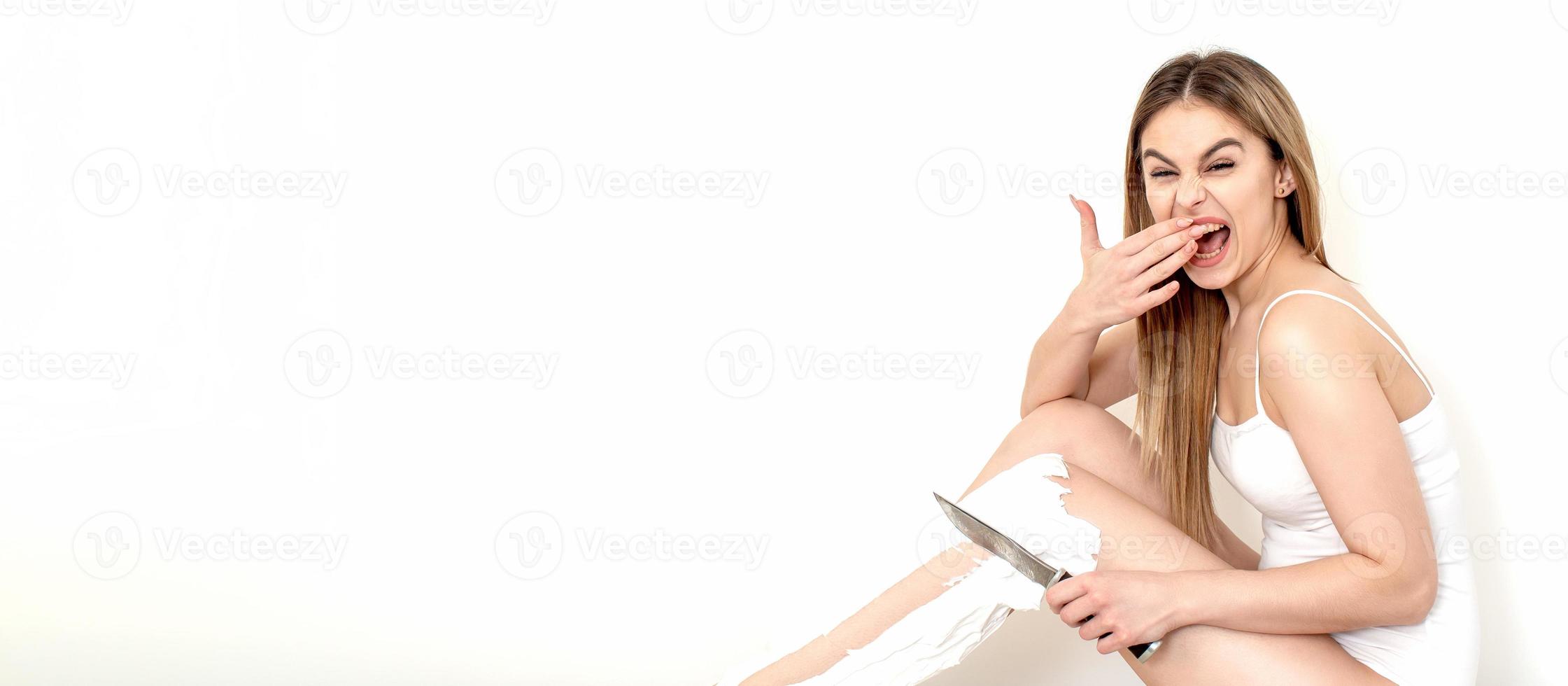 kvinna rakar henne ben med en kniv foto