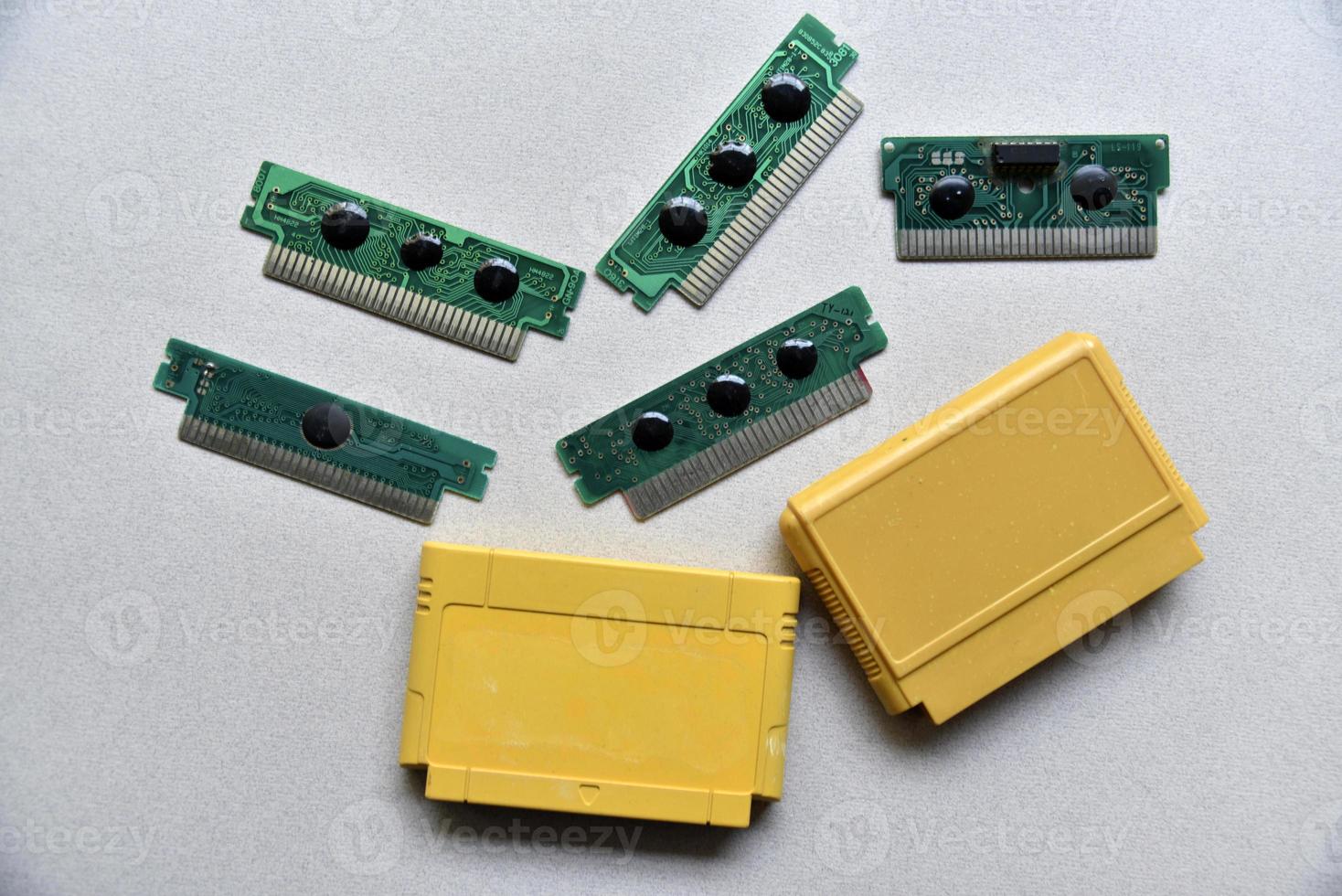 elektronisk patron styrelse för retro spel trösta. en gul plast patron på en svart bakgrund och ett elektronisk styrelse. foto