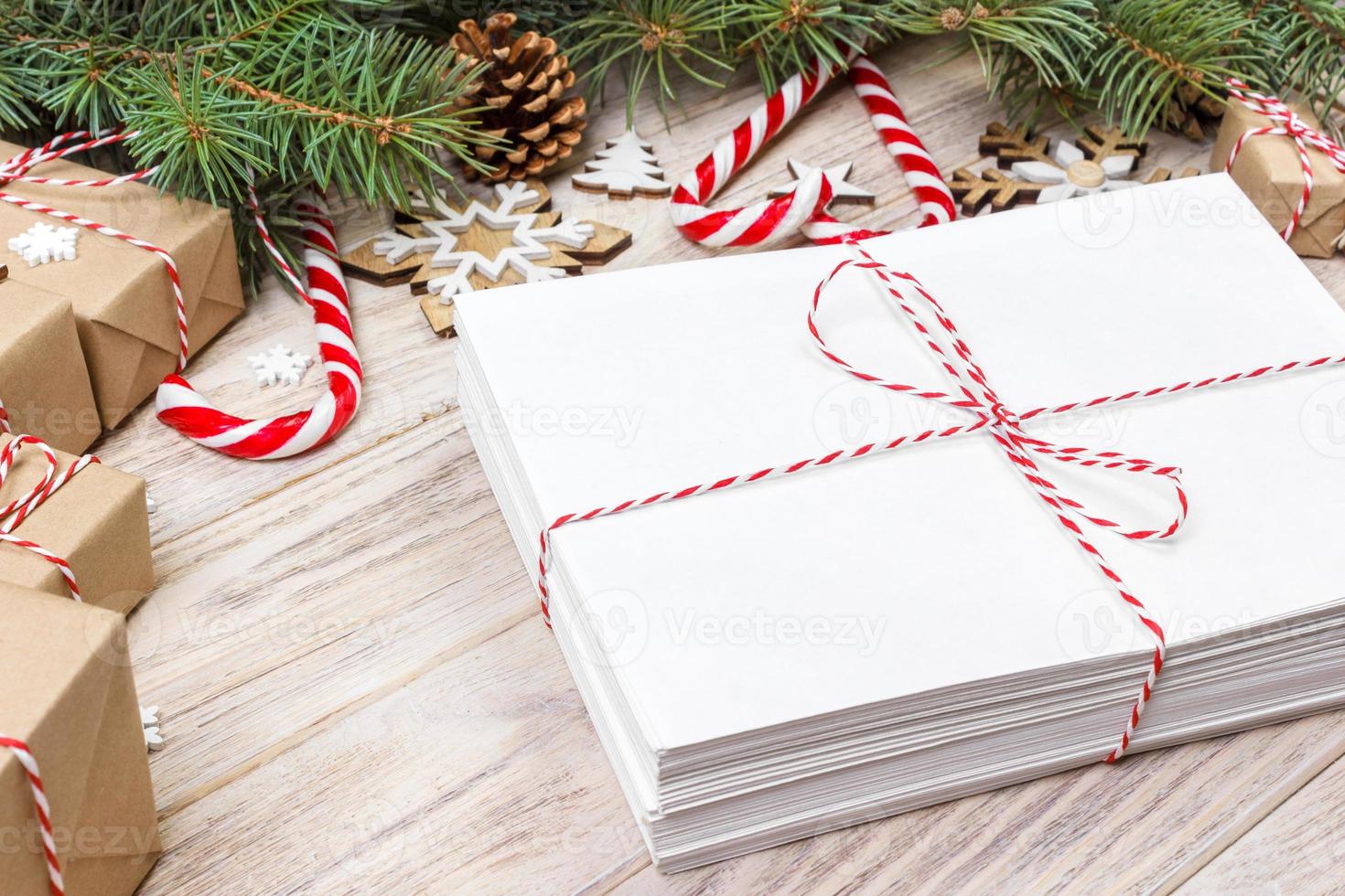 paket i kuvert med gran grenar och jul dekoration på en trä- bakgrund foto