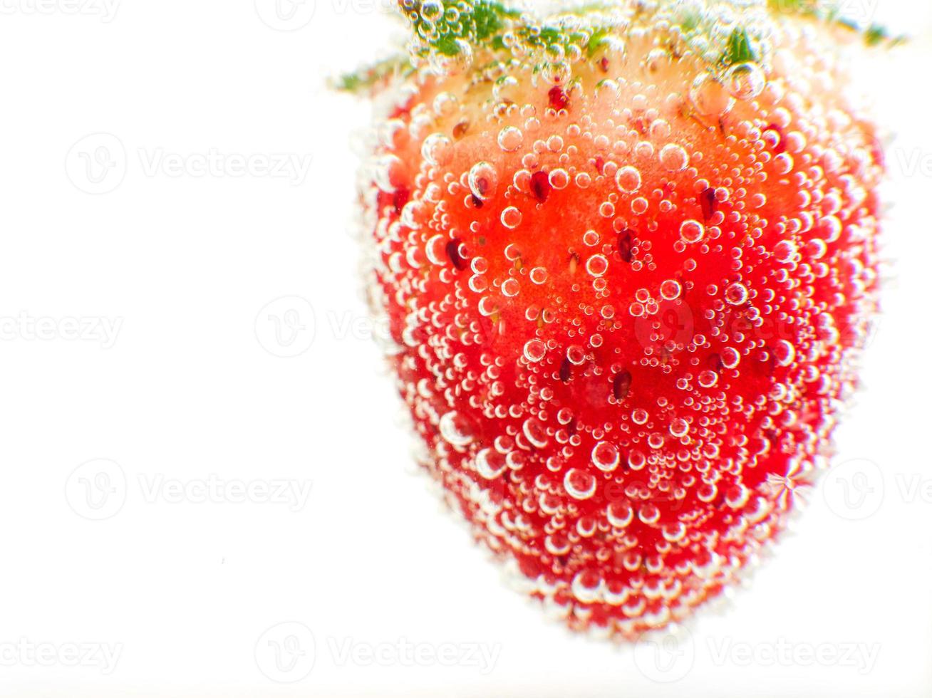 närbild jordgubb i gnistrande vatten vit bakgrund foto