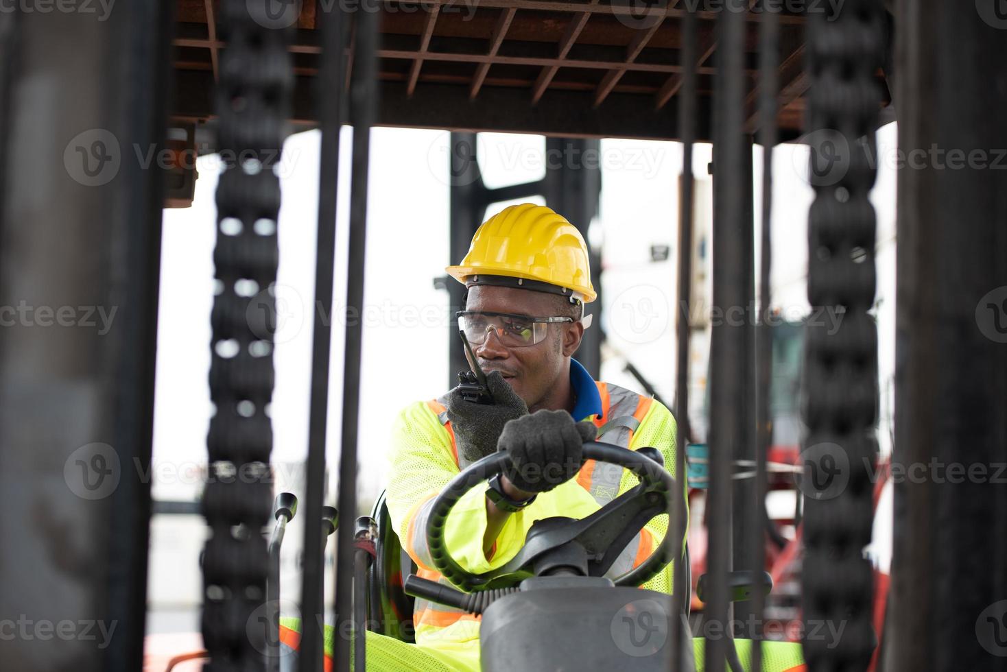 arbetstagare man körning gaffeltruck i industriell behållare lager, pratar på walkie talkie. foto