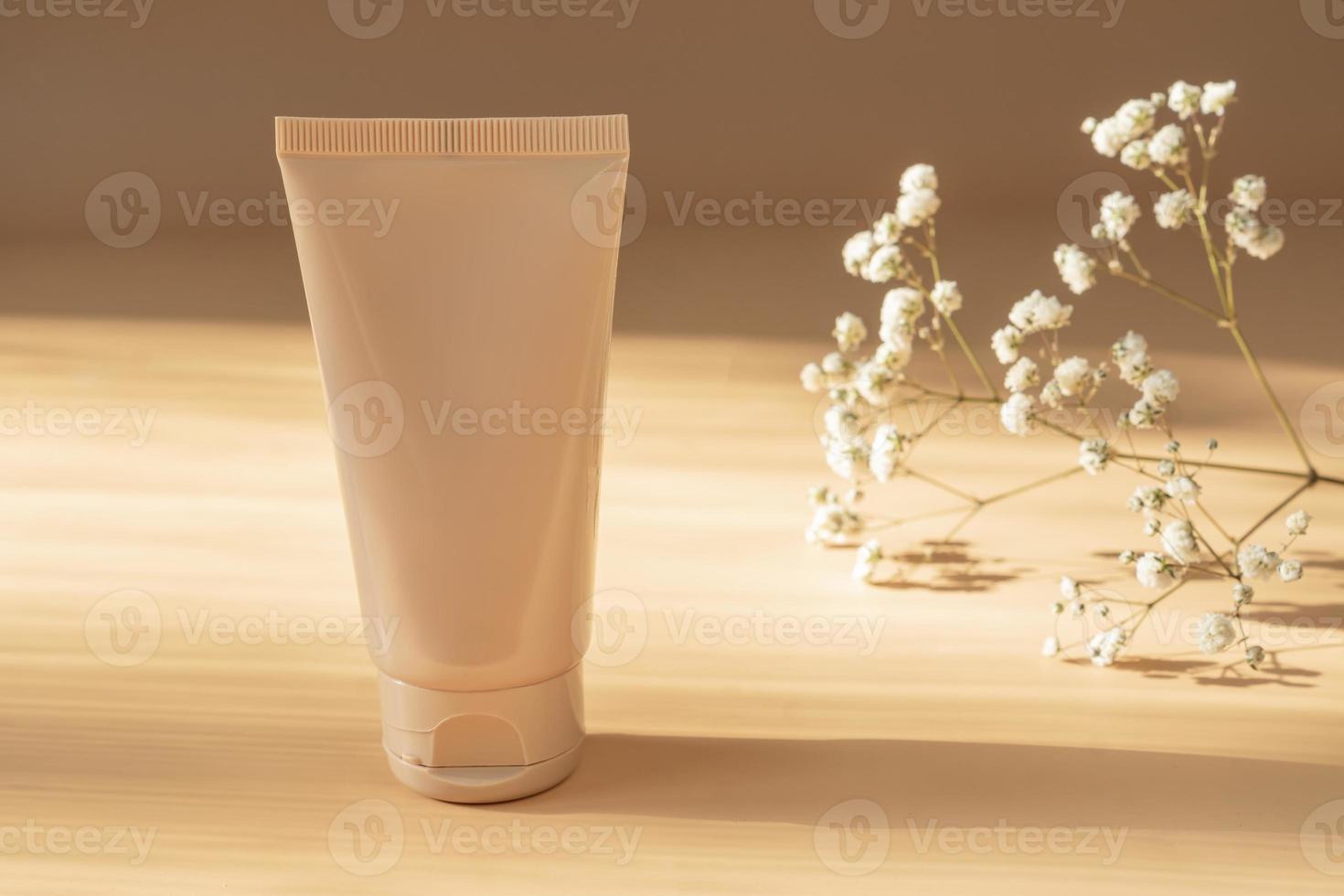 grädde rör på ljus solig beige bakgrund. kosmetisk hudvård produkt tom plast paket. beige omärkt lotion, balsam, hand creme mockup. Solskydd grädde flaska. foto