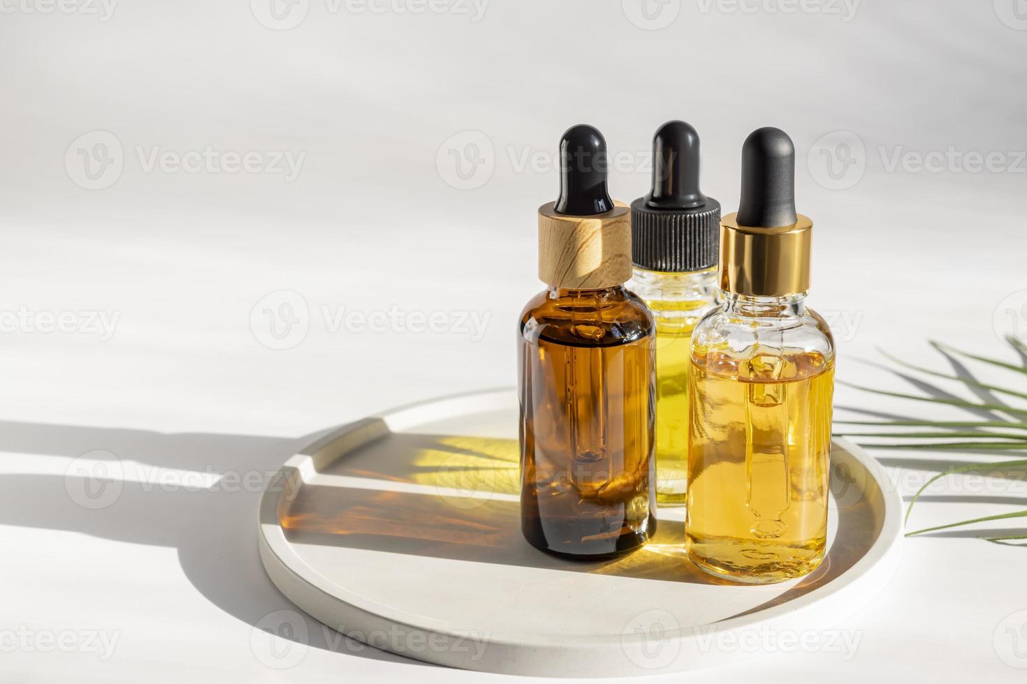 estetisk minimalistisk skönhet vård terapi begrepp. organisk serum olja kosmetika flaskor på keramisk bricka mot vit bakgrund. kropp, hud, ansikte behandling produkt sammansättning foto