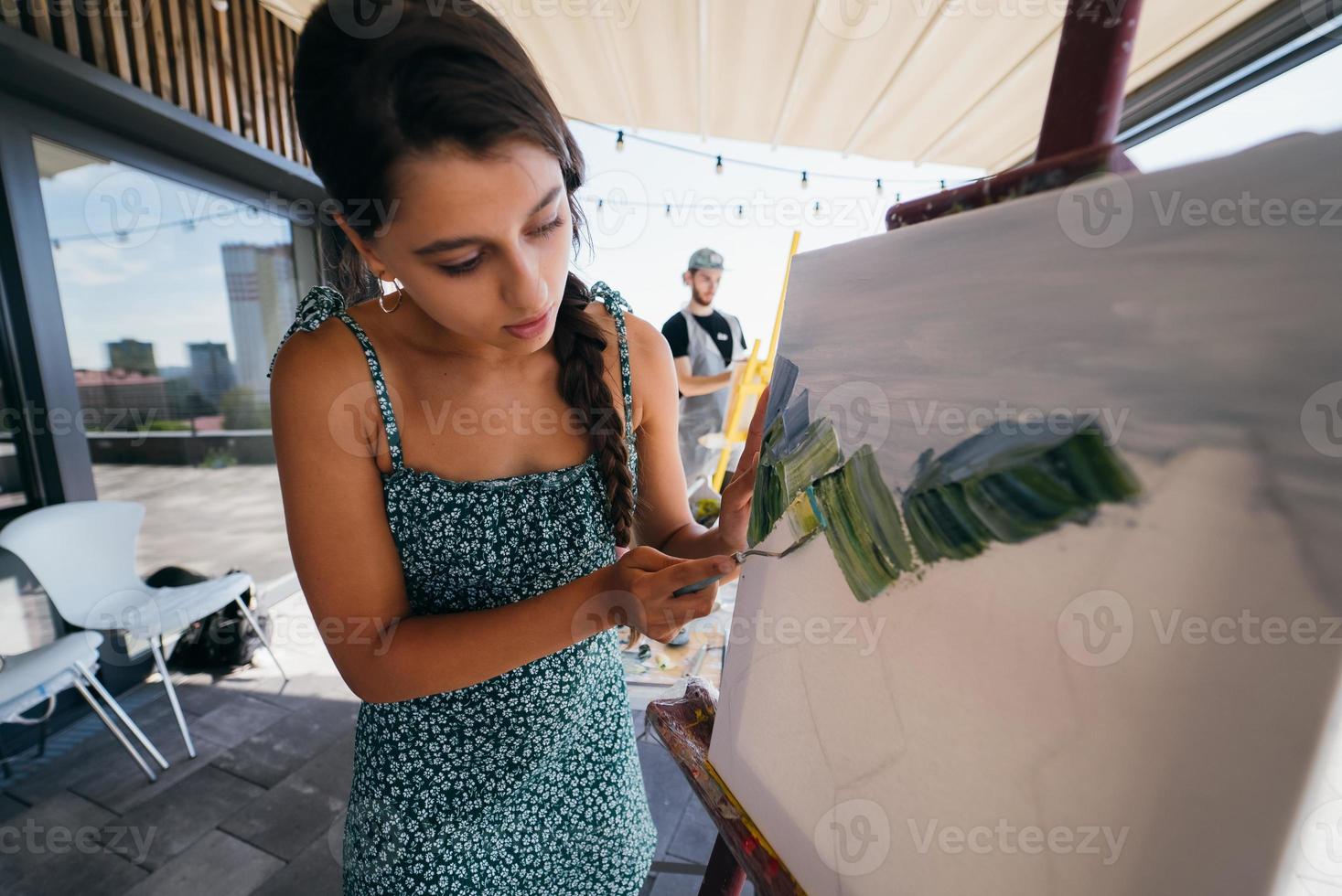 ung kvinna konstnär målarfärger med en spatel på de duk foto