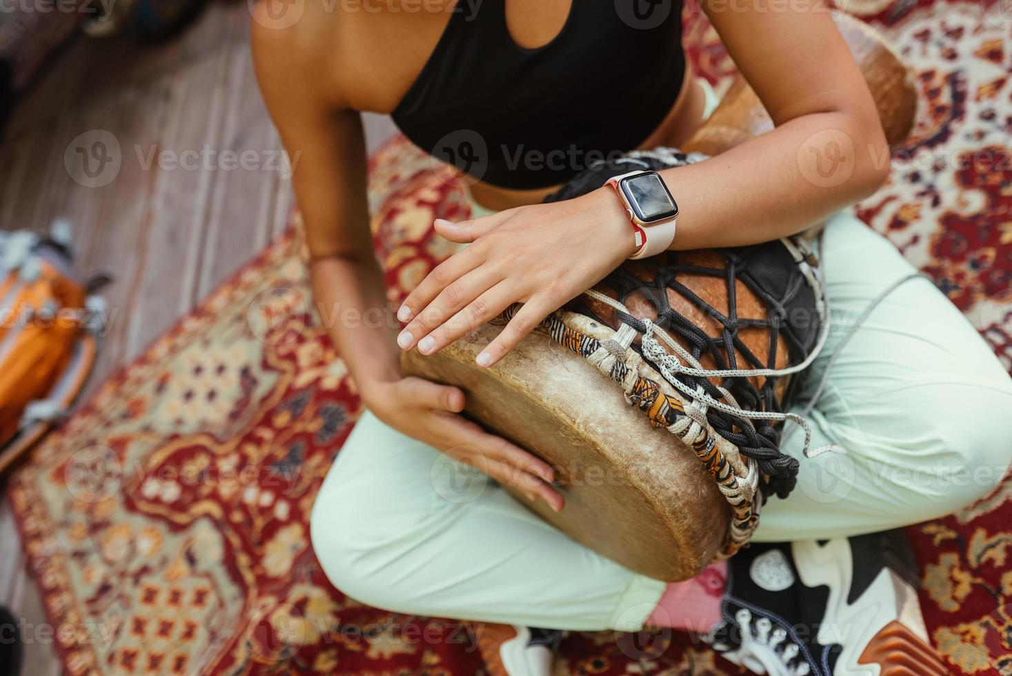 en ung skön kvinna spelar en hand trumma foto