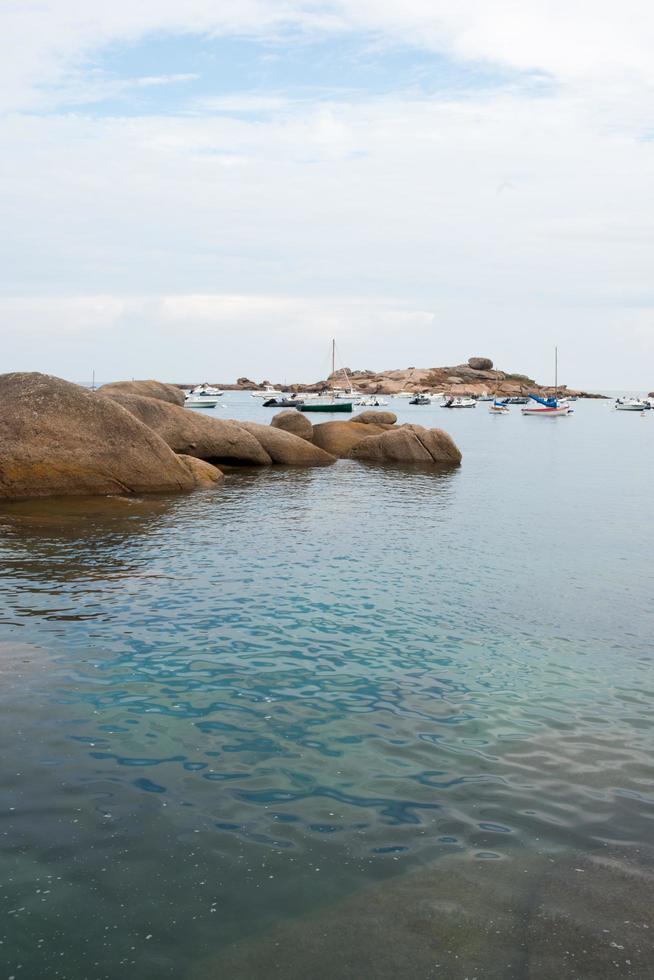 skön marinmålning med stenar och klar vatten. rosa granit kust i Frankrike. foto