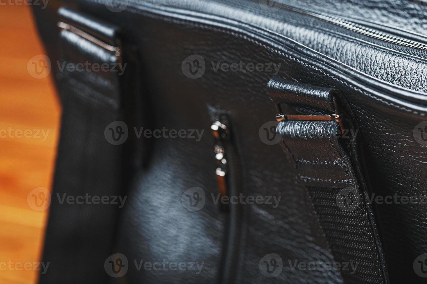 handgjort svart läder väska på en trä- bakgrund, tillverkad av naturlig material. foto