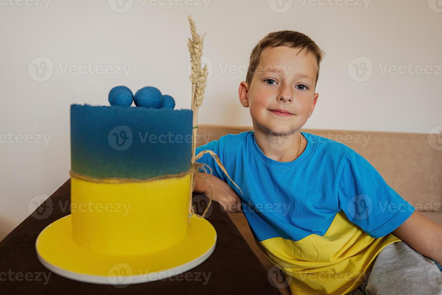 ukrainska pojke unge fira födelsedag innehav stor kaka med flagga av ukraina. foto