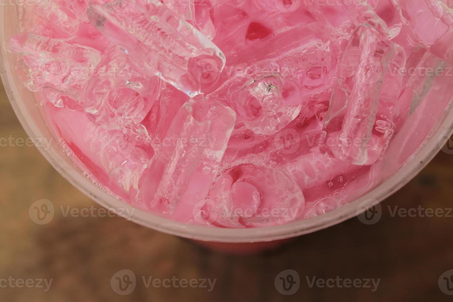 närbild topp se is av jordgubb ljuv mjölk rosa i hämtmat kopp. foto