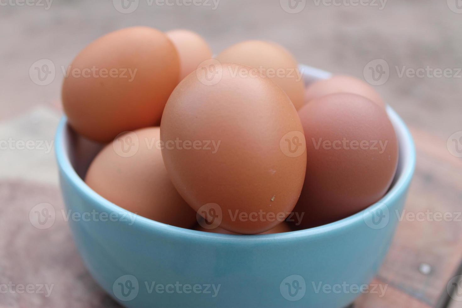 närbild se av rå kyckling ägg i blå skål foto
