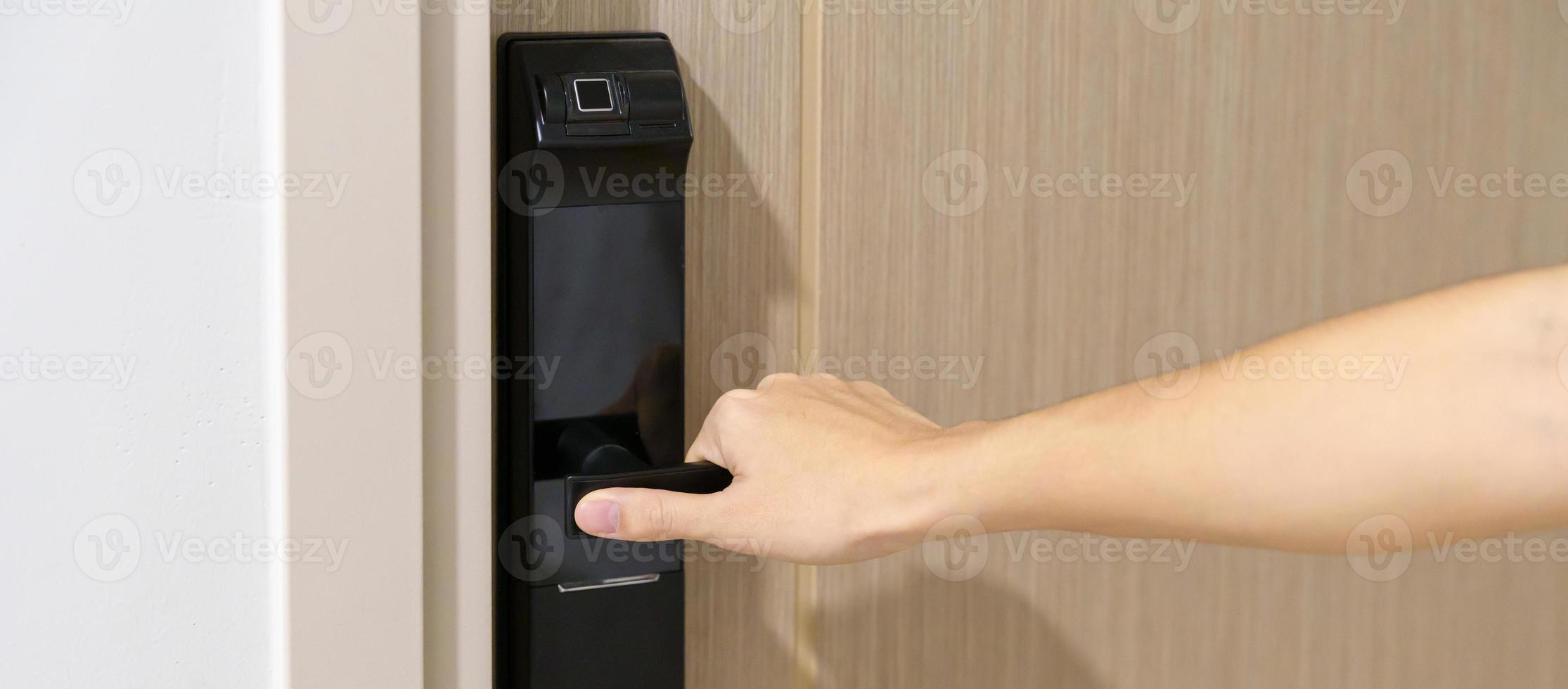 man håller handtaget på smart digitalt dörrlås medan du öppnar eller stänger dörren. teknik, el och livsstilskoncept foto