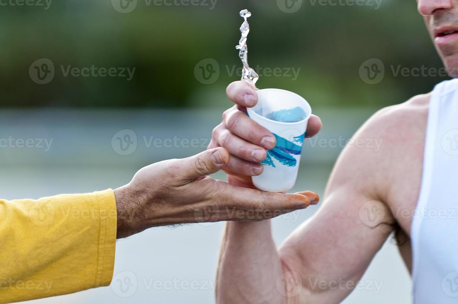 en maratonlöpning som håller en kopp vatten foto