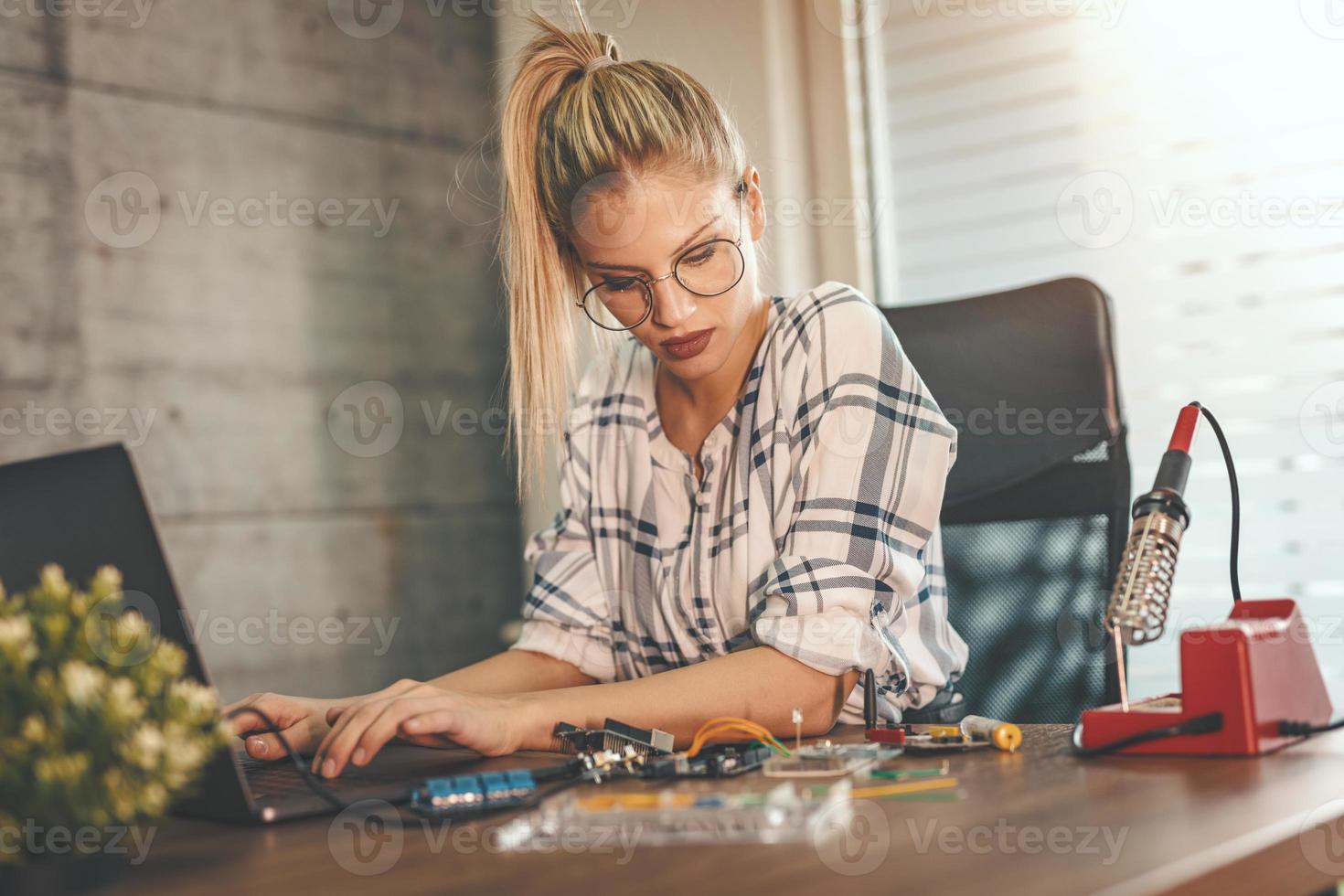 kvinna ingenjör testning krets styrelse i henne kontor foto