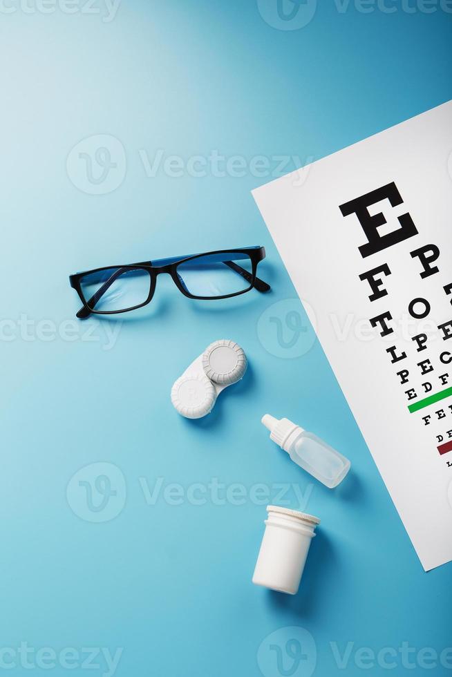 oftalmisk Tillbehör glasögon och linser med ett öga testa Diagram för syn korrektion på en blå bakgrund foto