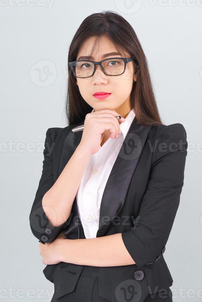 ung asiatisk flicka bär kostym med Stöd hand på haka foto