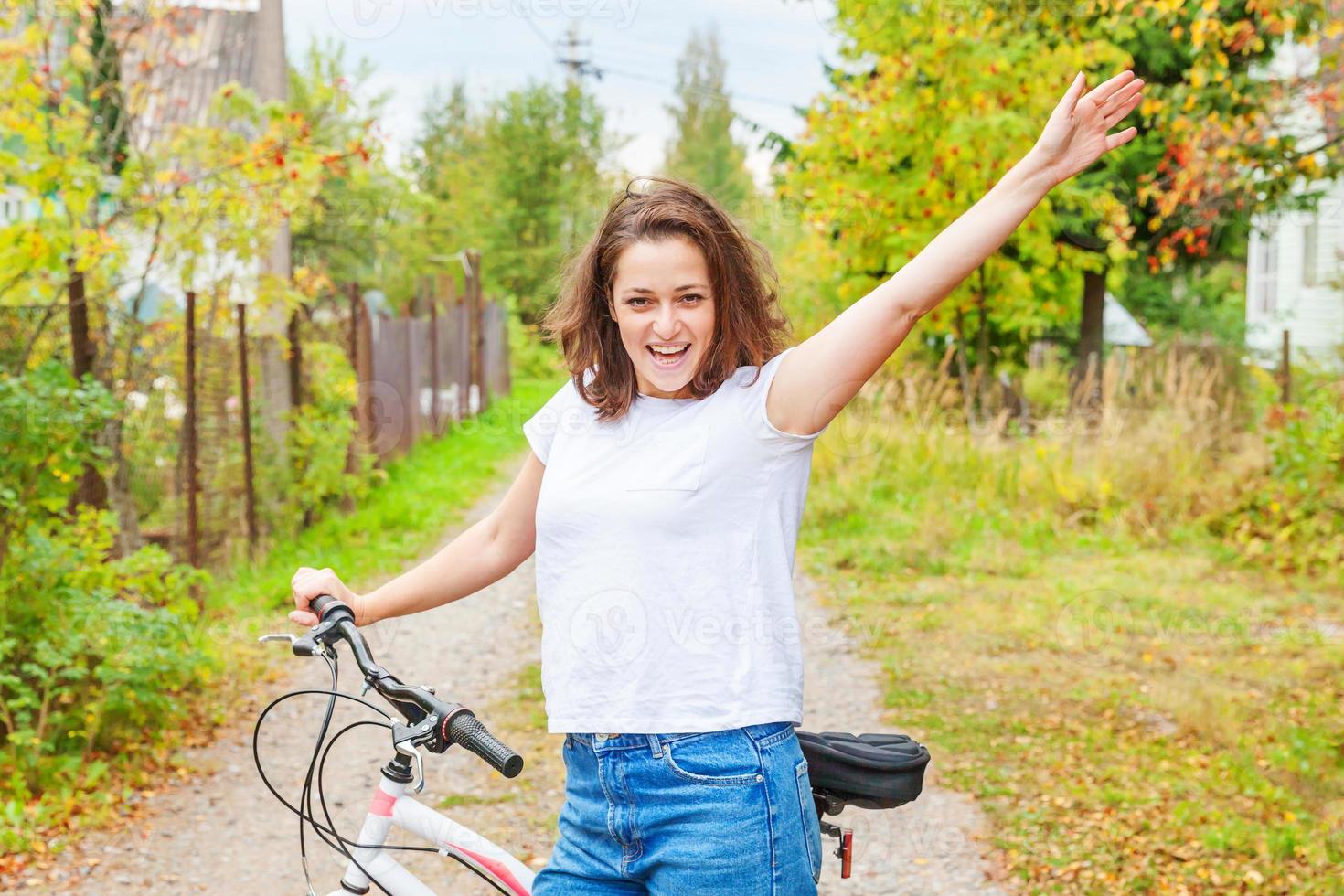 ung kvinna ridning cykel i sommar stad parkera utomhus. aktiva människor. hipster flicka koppla av och ryttare cykel. cykling till arbete på sommar dag. cykel och ekologi livsstil begrepp. foto