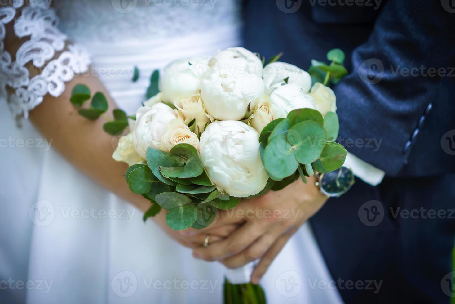 de brud innehar en bröllop bukett i henne händer, bröllop dag blommor. foto