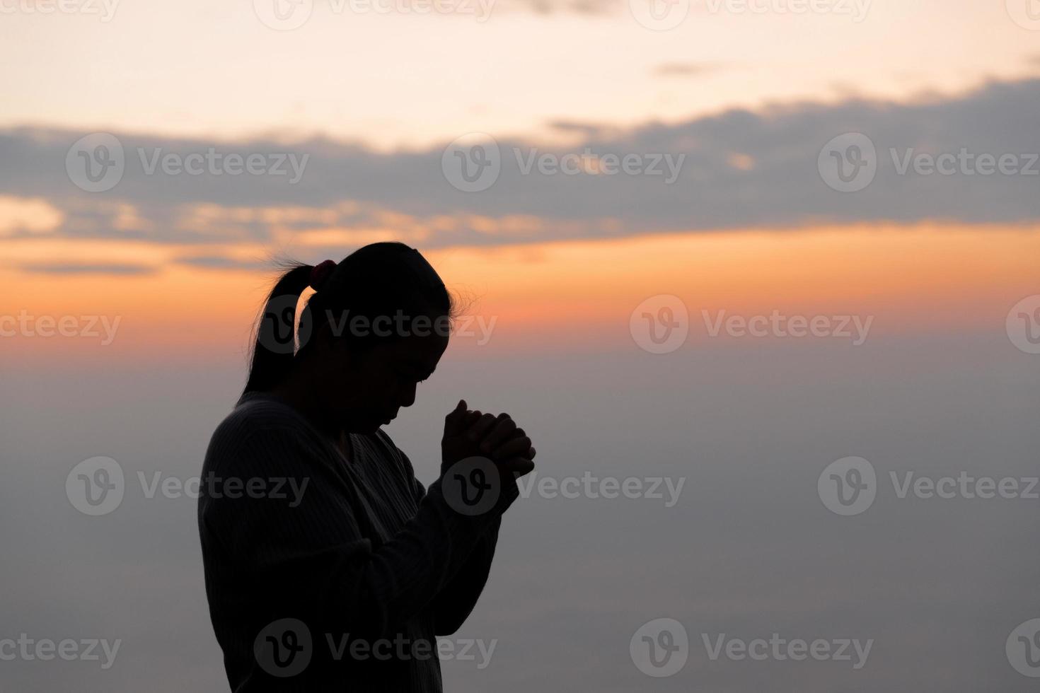 silhuett av kvinna hand bön- andlighet och religion, kvinna dyrkan till Gud. kristendomen religion begrepp. religiös människor är ödmjuk till Gud. kristna ha hoppas tro och tro i Gud. foto