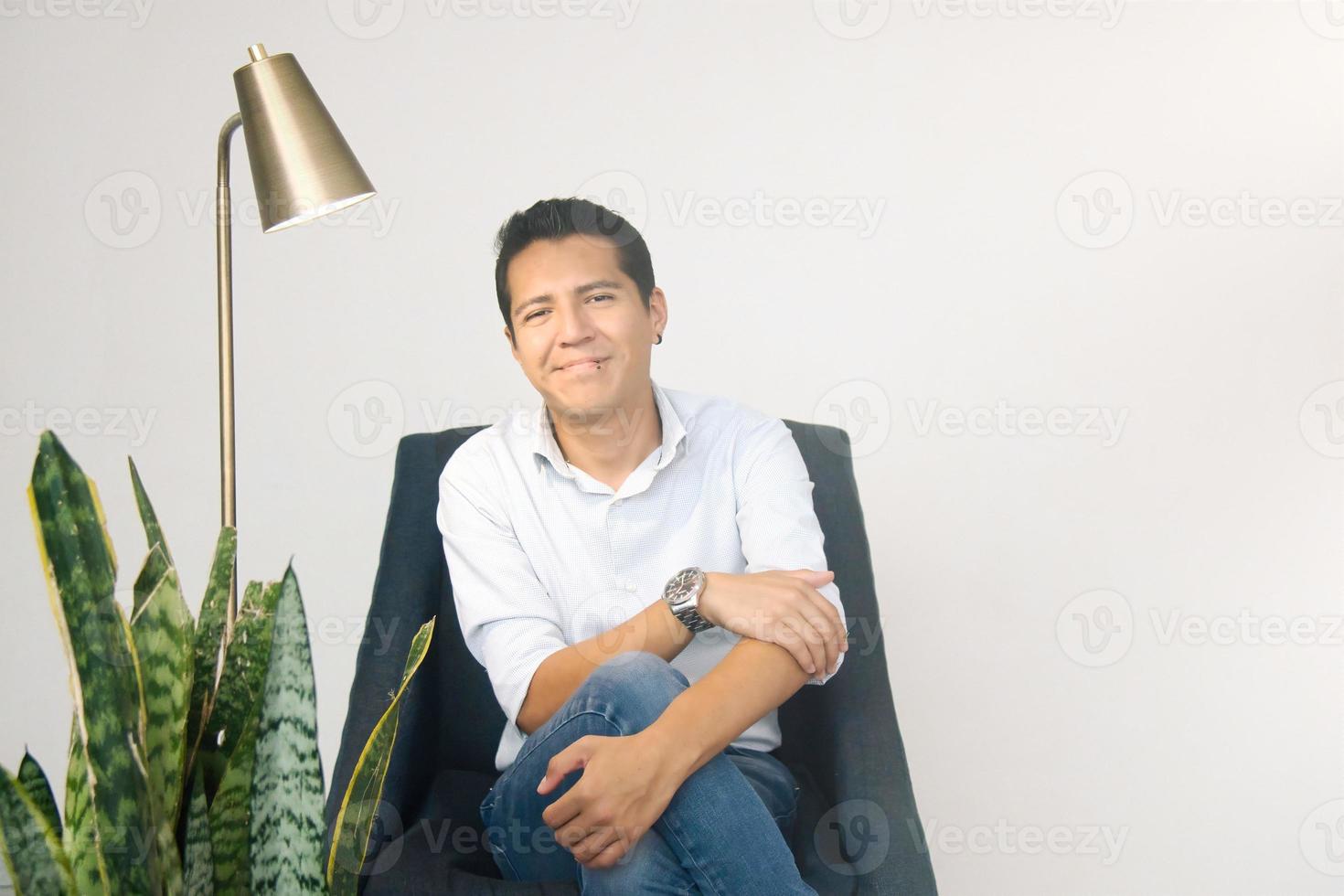 Lycklig manlig psykolog Sammanträde i hans kontor foto