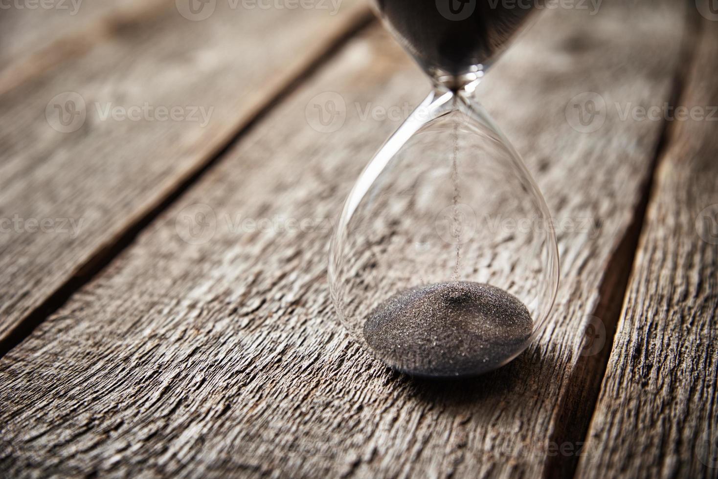 timglas på trä- bakgrund, närbild. brådskande karaktär och löpning ut av tid begrepp foto