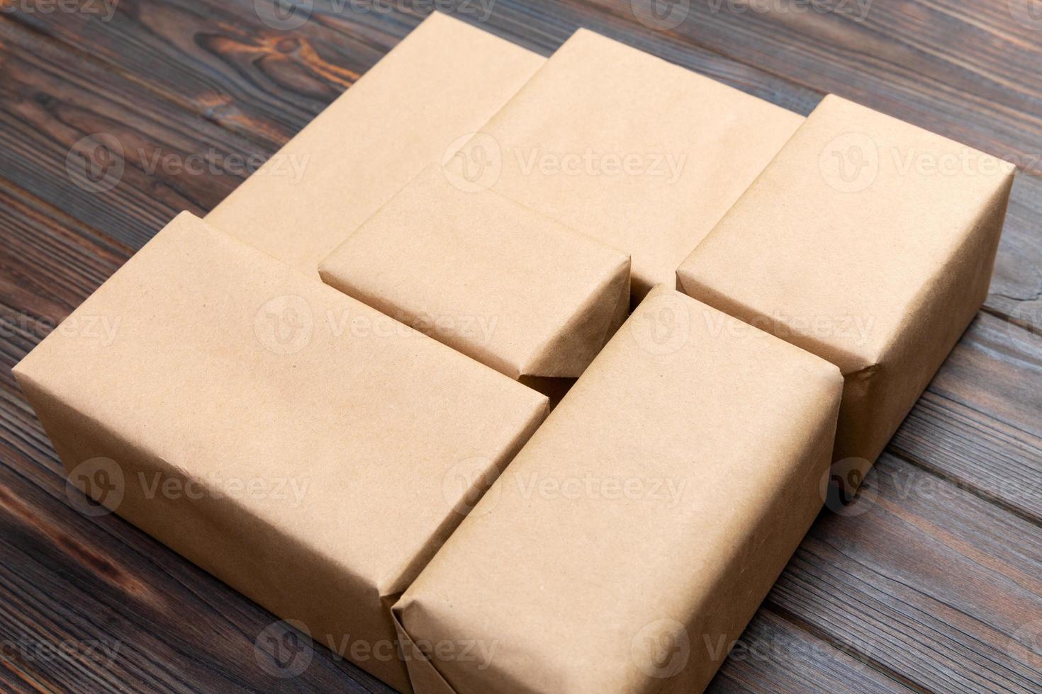 brun post paket paket tom för du design. kartong låda på en mörk trä- bakgrund foto